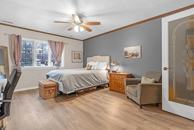 bedroom featuring visible vents, a ceiling fan, crown molding, light wood finished floors, and baseboards