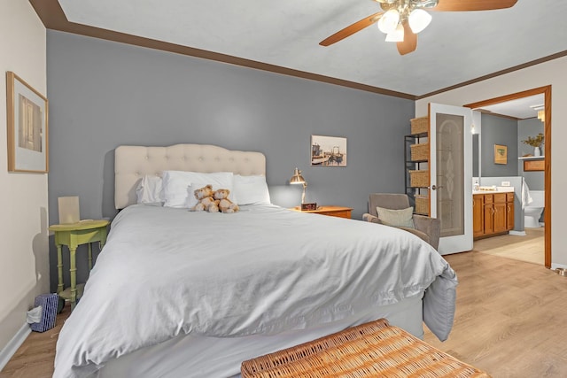 bedroom with light wood-type flooring, baseboards, ensuite bath, and crown molding