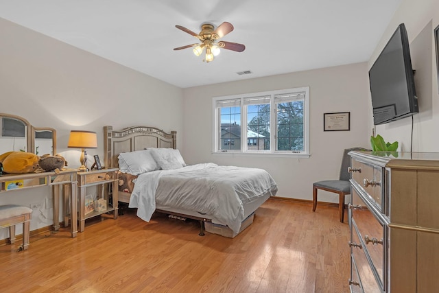 bedroom with light wood finished floors, visible vents, ceiling fan, and baseboards