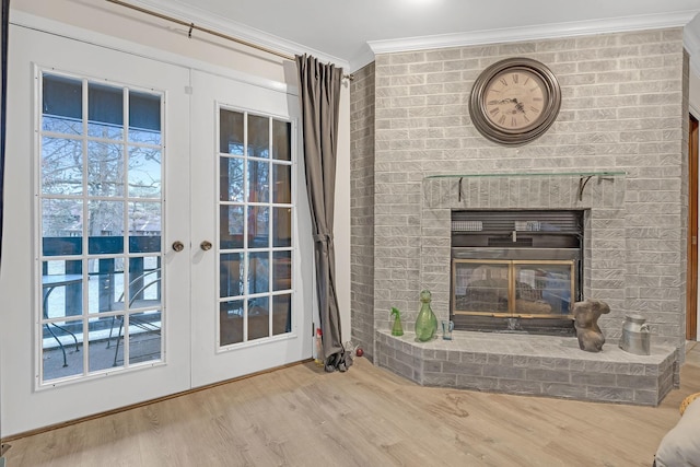 unfurnished living room featuring a brick fireplace, wood finished floors, french doors, and ornamental molding