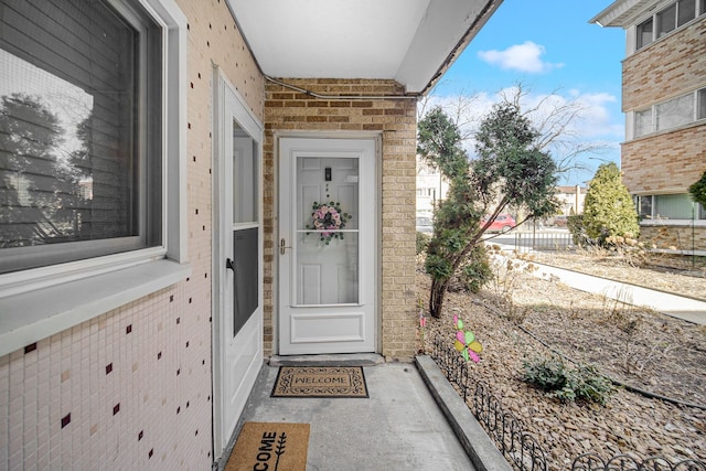 view of exterior entry featuring brick siding