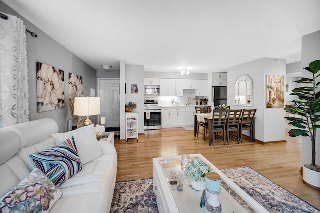 living area featuring light wood-style flooring and baseboards