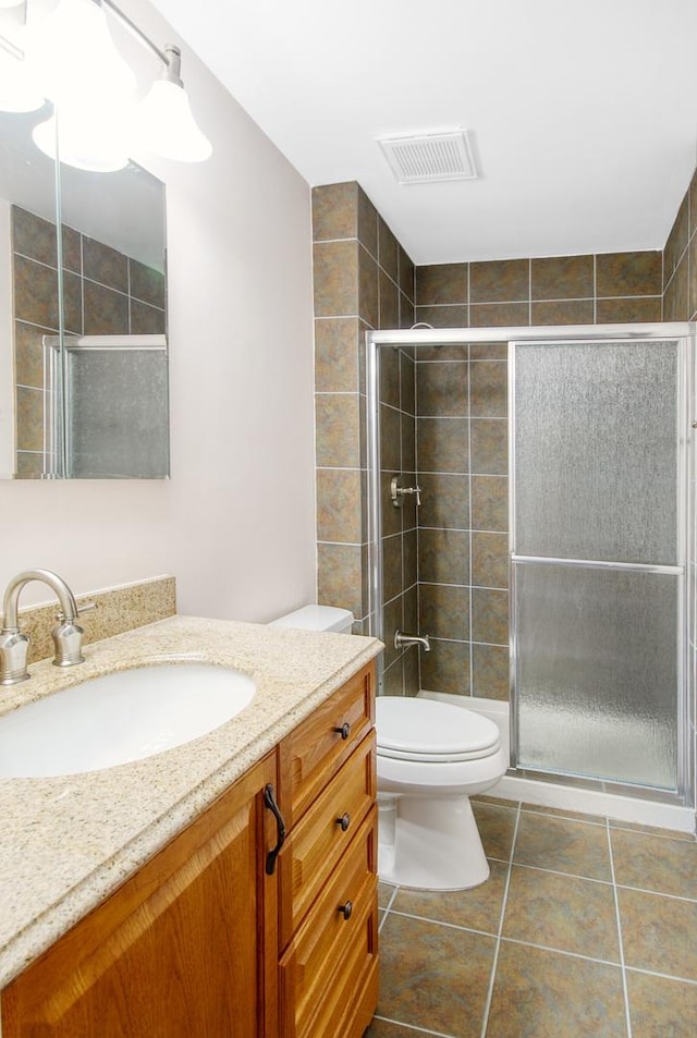 bathroom featuring visible vents, toilet, a stall shower, and tile patterned flooring