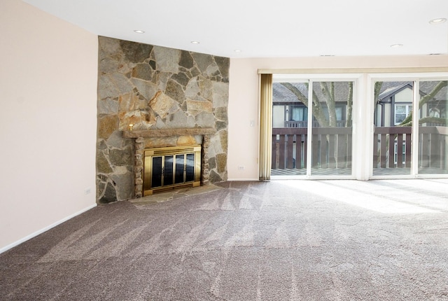 unfurnished living room with baseboards, carpet floors, and a stone fireplace