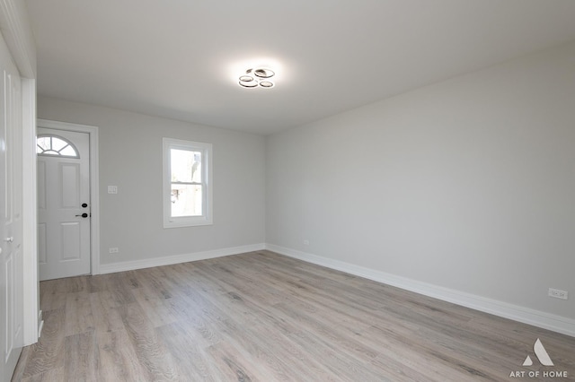 interior space with baseboards and light wood finished floors