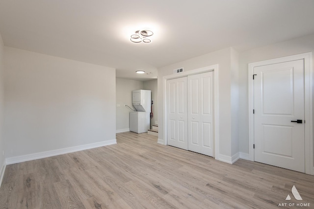 unfurnished bedroom featuring a closet, baseboards, visible vents, and light wood finished floors