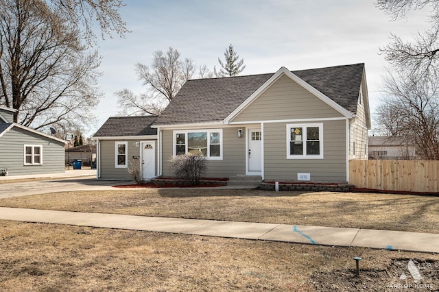 bungalow-style house featuring a shingled roof and fence