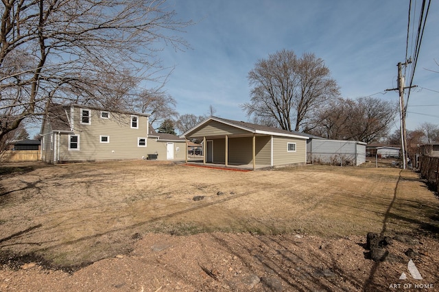 back of property featuring a yard and fence