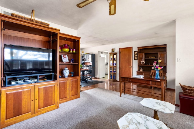 carpeted living area with ceiling fan