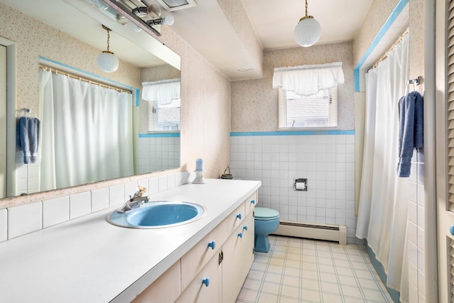 bathroom featuring toilet, tile walls, wainscoting, wallpapered walls, and baseboard heating