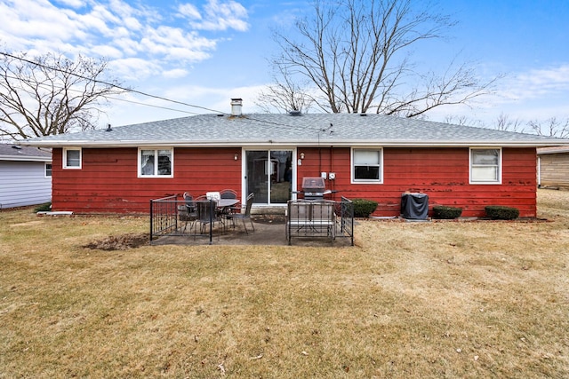 rear view of house with a lawn, roof with shingles, and a patio area