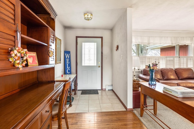 entryway featuring a baseboard heating unit, baseboards, and light wood-style floors