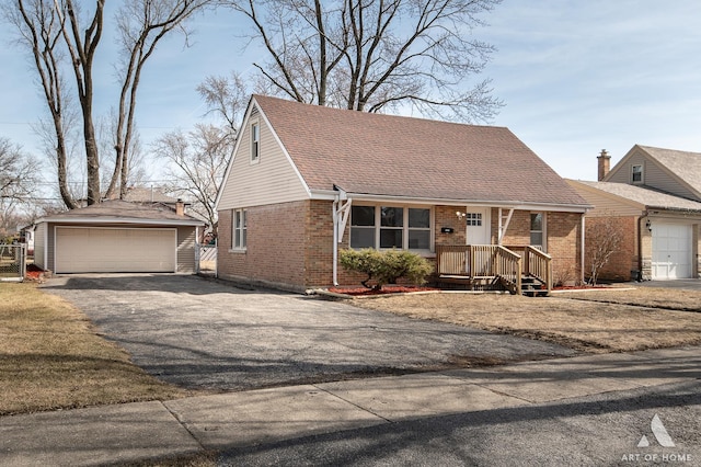 view of front facade featuring brick siding, an outbuilding, and a garage