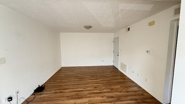 spare room with wood finished floors and visible vents