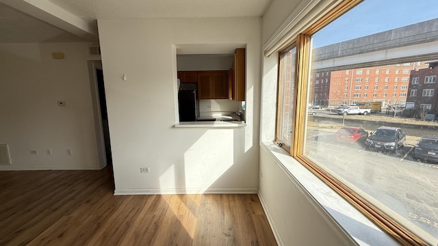 unfurnished room featuring visible vents, baseboards, and wood finished floors