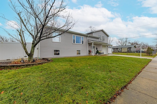 view of front of house featuring concrete driveway, a front lawn, and fence