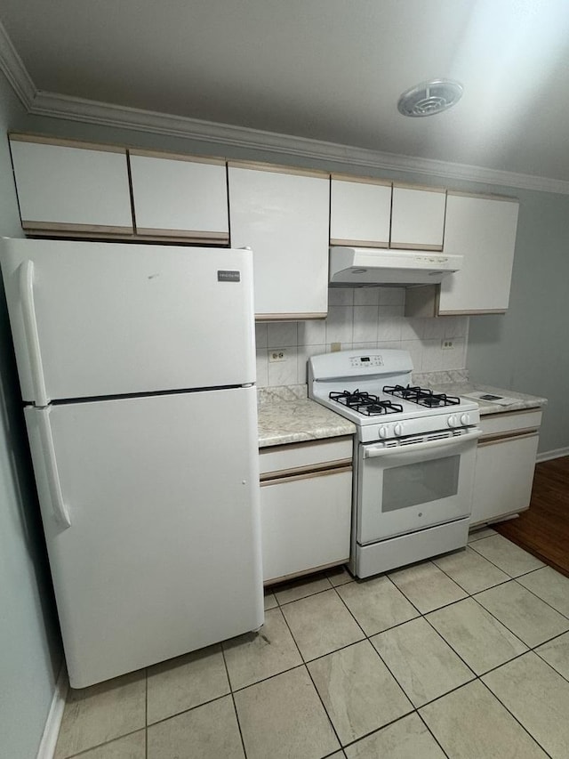 kitchen with under cabinet range hood, white appliances, white cabinets, crown molding, and light countertops