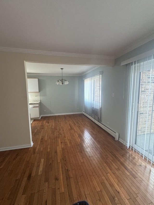 unfurnished dining area with ornamental molding, a baseboard heating unit, and hardwood / wood-style flooring