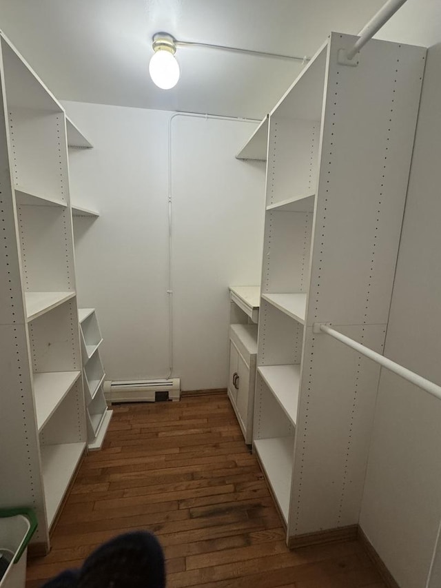 walk in closet featuring dark wood-type flooring and baseboard heating