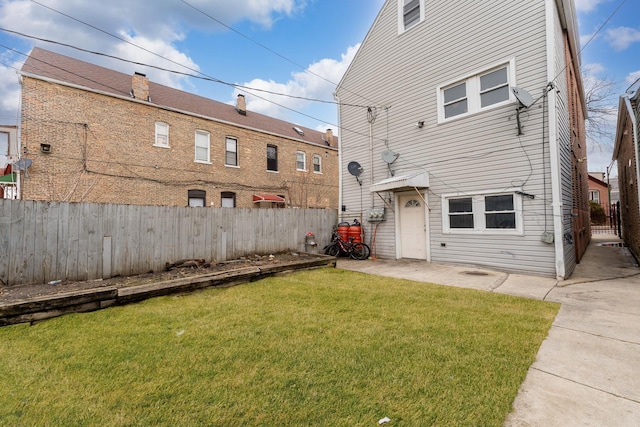 rear view of house with a patio area, a lawn, and fence