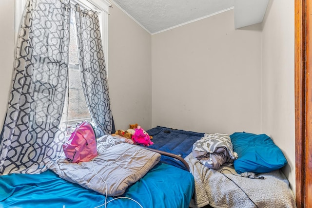 bedroom with a textured ceiling and ornamental molding