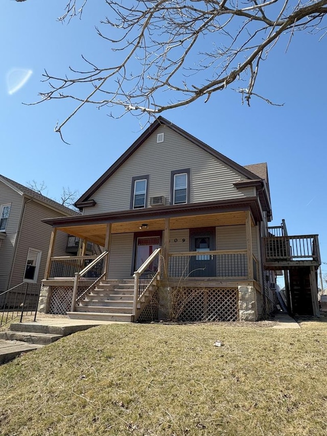 view of front of property with a porch, stairs, and a front yard