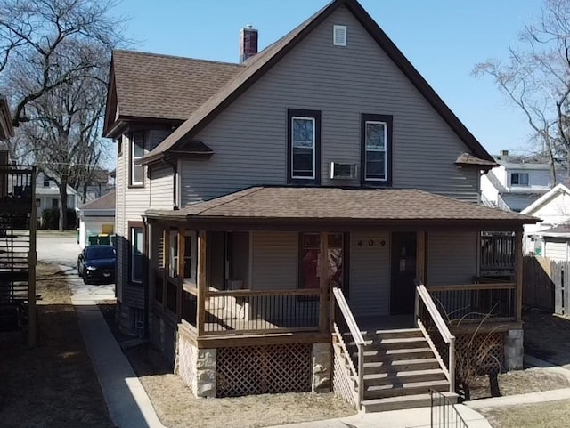 view of front of home with covered porch, roof with shingles, and a chimney