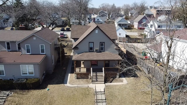 exterior space with a porch, fence, a residential view, and a front lawn