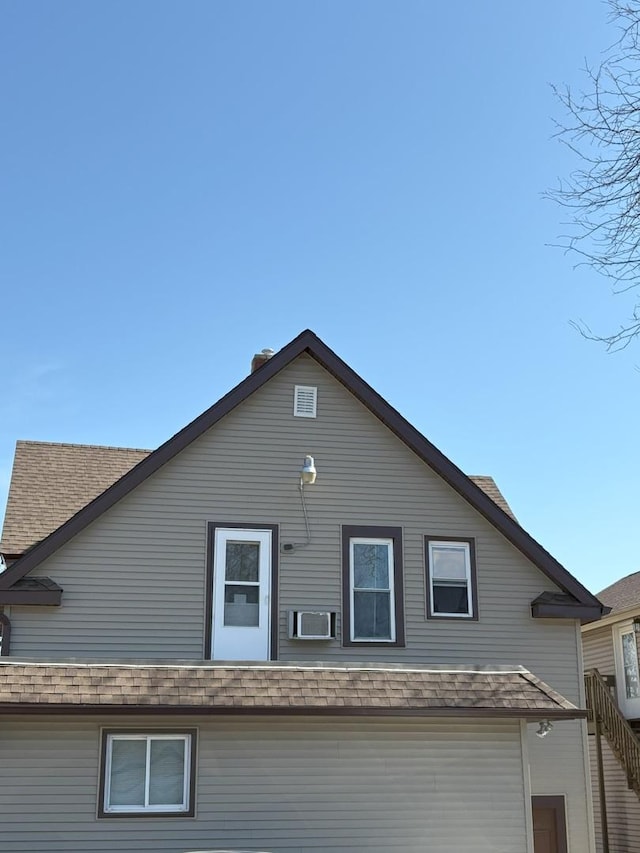 exterior space featuring roof with shingles