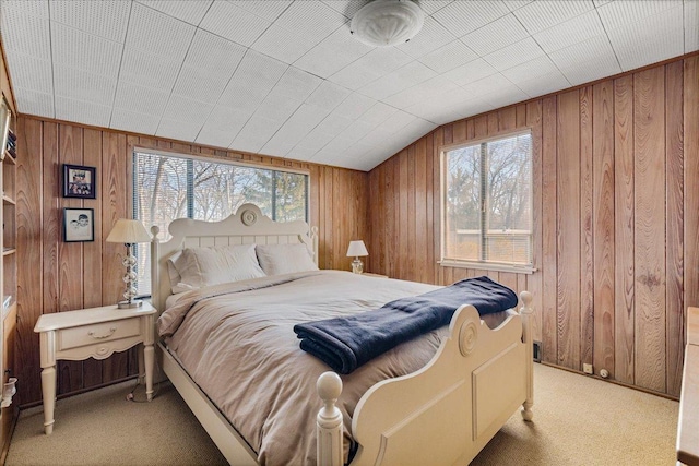 bedroom with multiple windows, carpet floors, and wood walls