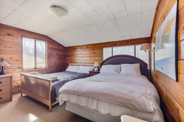 carpeted bedroom featuring vaulted ceiling, wooden walls, and multiple windows