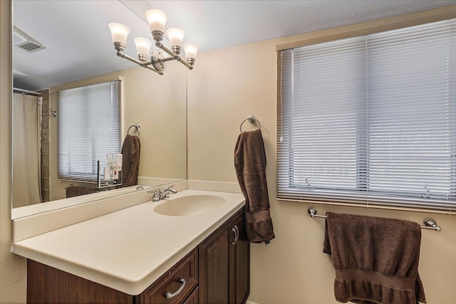 bathroom with visible vents, an inviting chandelier, and vanity