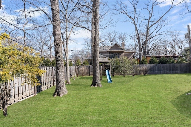 view of yard featuring a playground and a fenced backyard