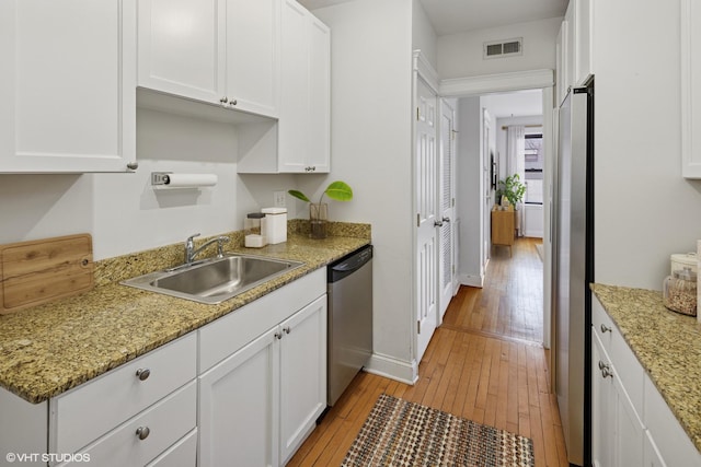 kitchen featuring a sink, visible vents, appliances with stainless steel finishes, and white cabinetry