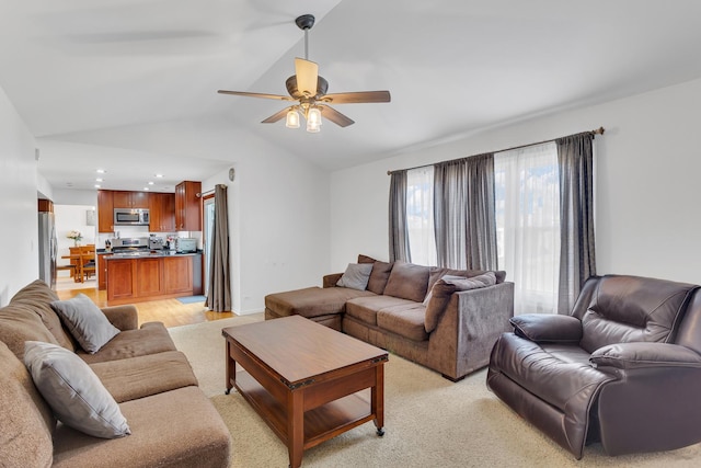 living area with ceiling fan and vaulted ceiling