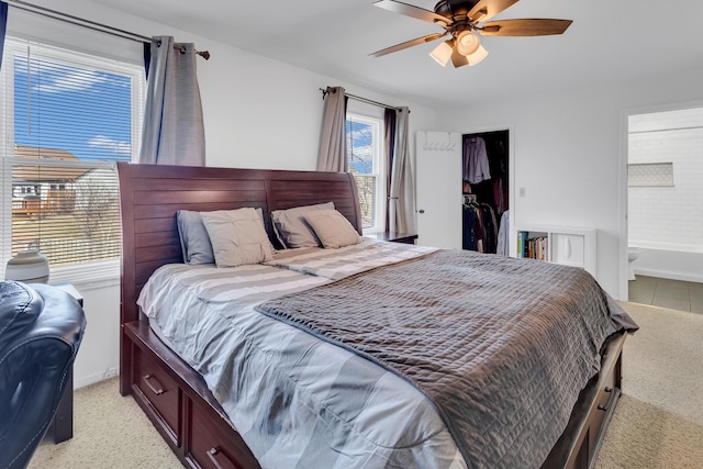 bedroom with a walk in closet, a closet, connected bathroom, and a ceiling fan