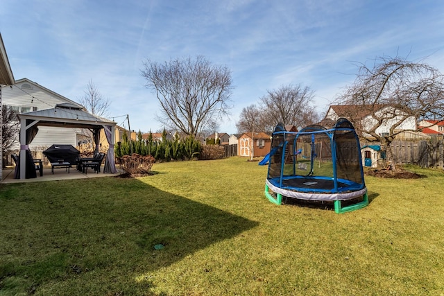 view of yard with a trampoline, a shed, a gazebo, an outdoor structure, and a patio