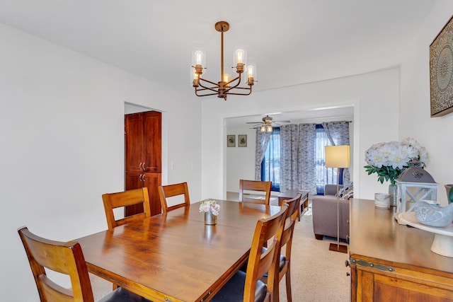 dining space featuring ceiling fan with notable chandelier