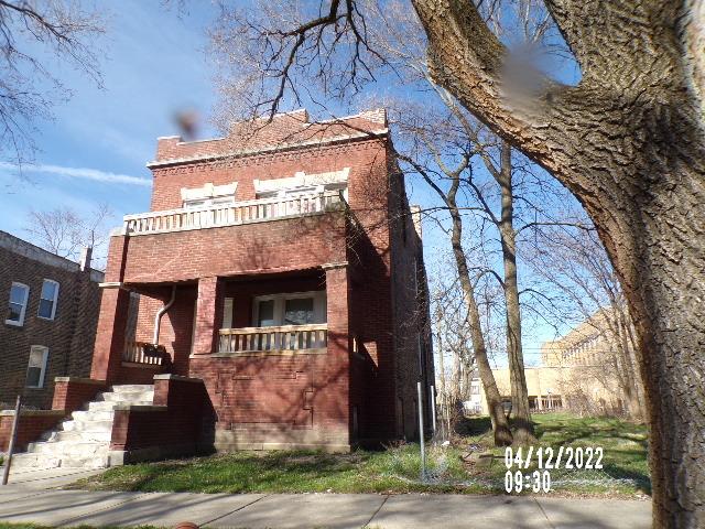 view of front of property featuring a balcony and brick siding