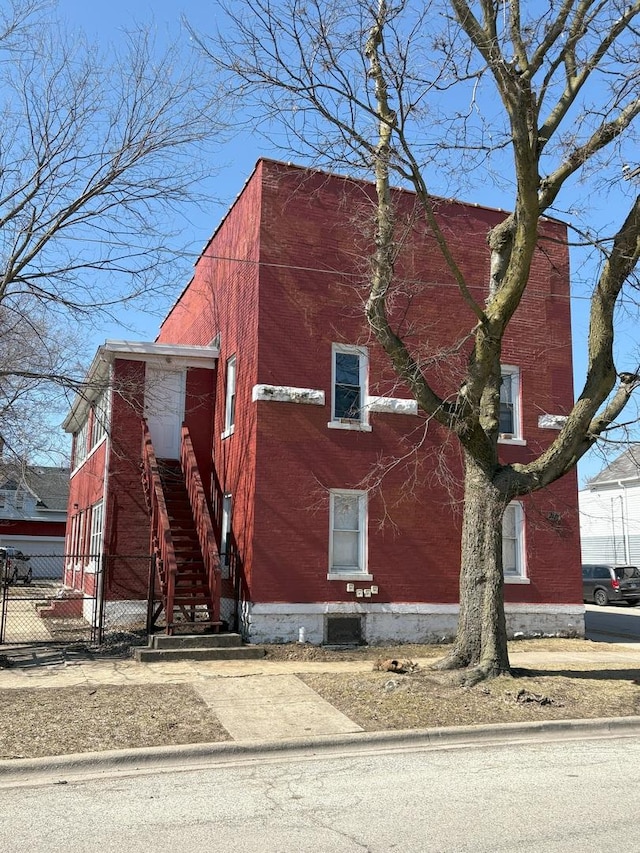 view of home's exterior featuring brick siding and fence