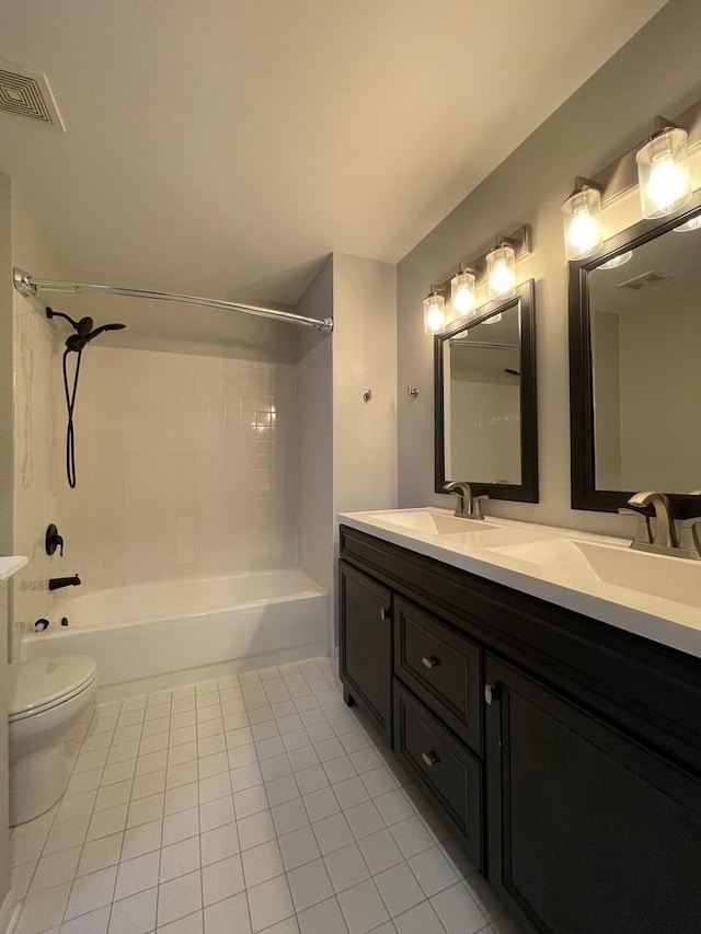 bathroom with toilet, double vanity, bathtub / shower combination, tile patterned floors, and a sink