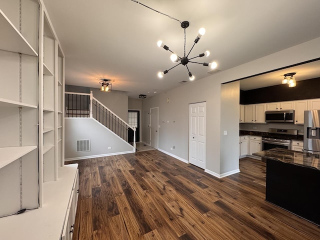 unfurnished living room featuring stairs, visible vents, dark wood-style floors, and baseboards