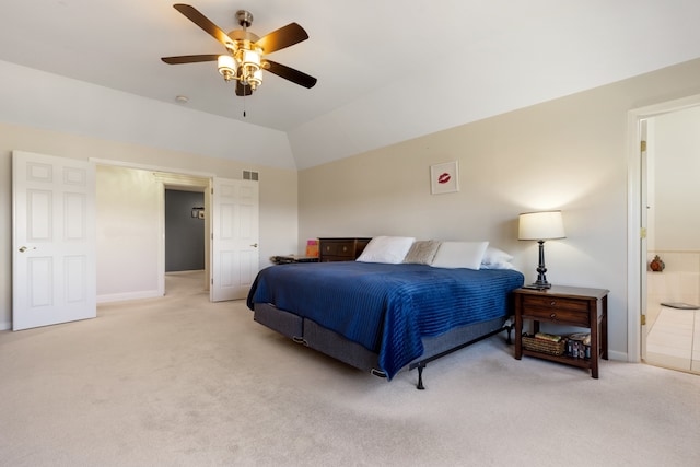 bedroom with visible vents, ensuite bath, light colored carpet, ceiling fan, and vaulted ceiling