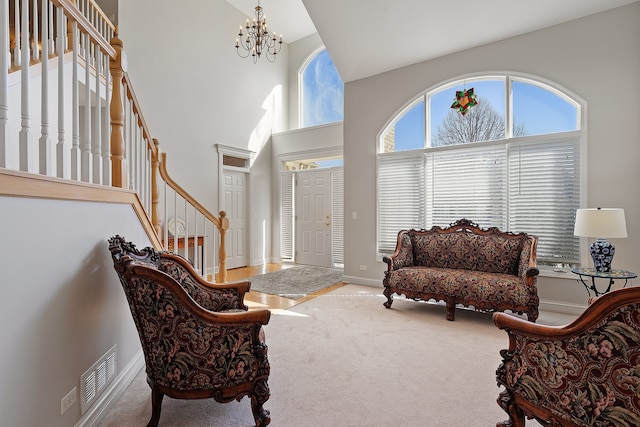 sitting room with stairway, visible vents, a high ceiling, a notable chandelier, and carpet flooring