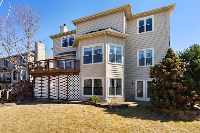 back of property with a wooden deck, stairs, a lawn, french doors, and a chimney