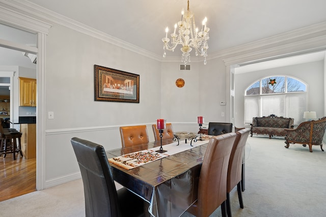 dining area featuring baseboards, visible vents, light carpet, crown molding, and a chandelier