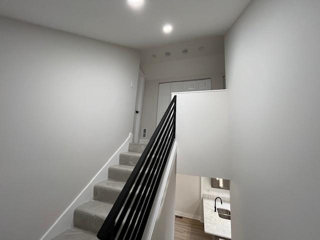 stairs with wood finished floors and baseboards