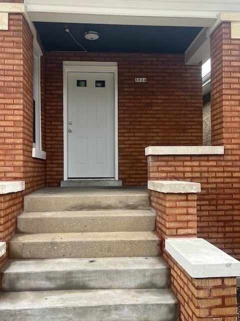 view of exterior entry with brick siding