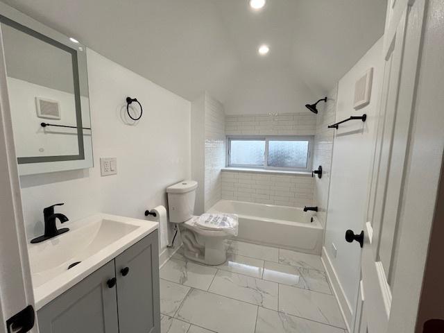 bathroom with toilet, lofted ceiling, shower / bathtub combination, marble finish floor, and vanity