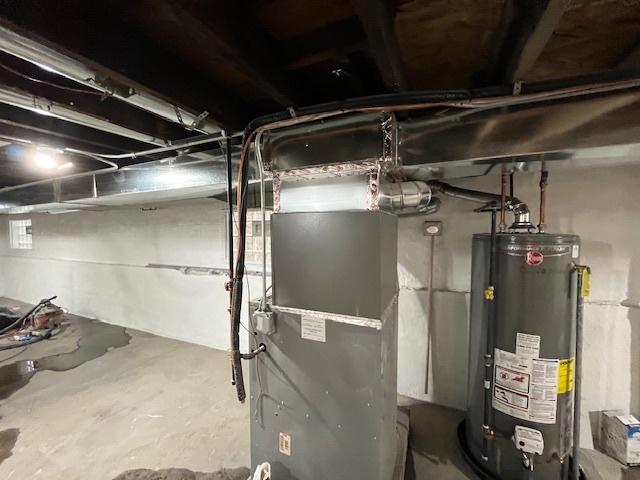 utility room featuring gas water heater and heating unit